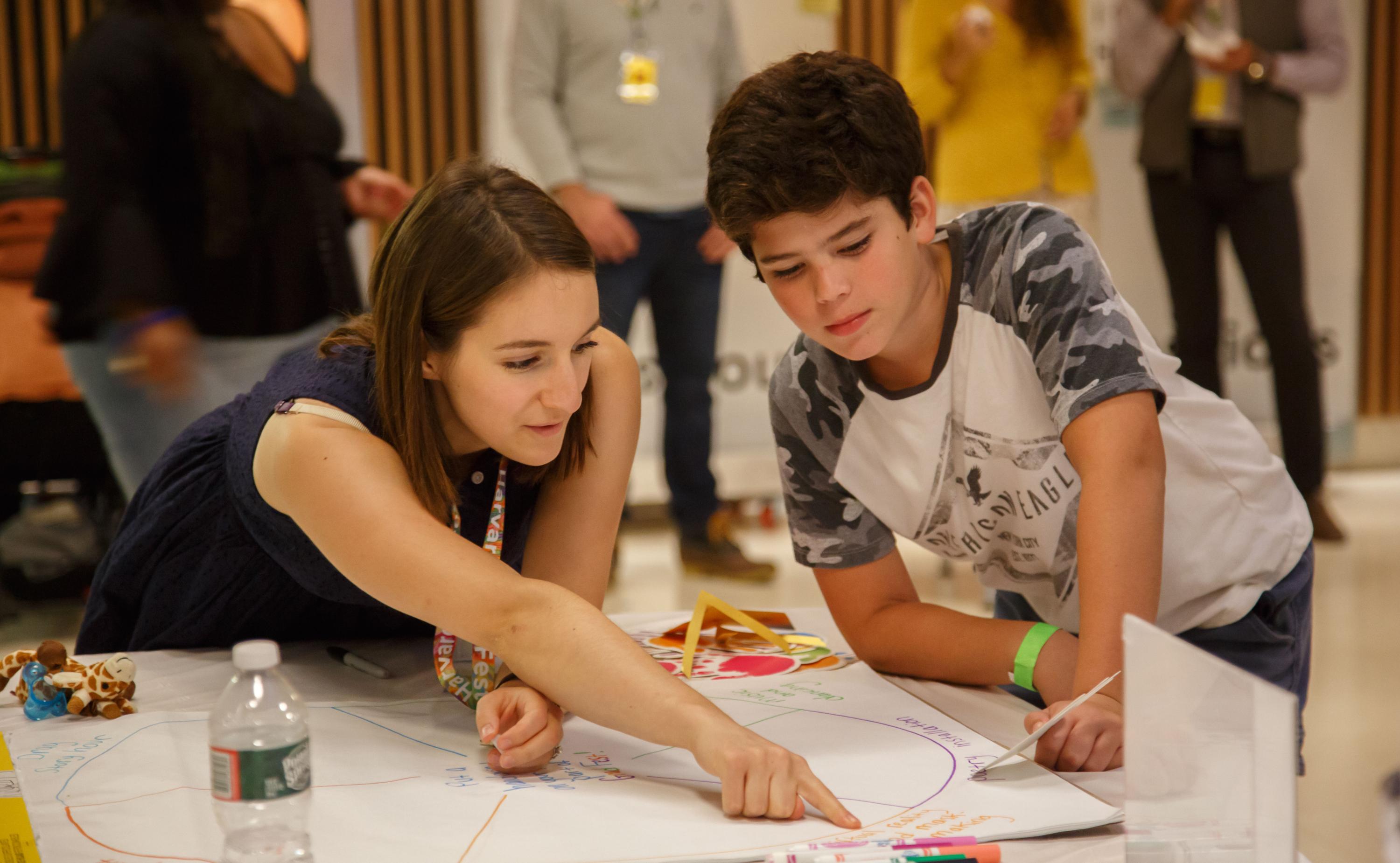 An adult gently instructing a child during an arts and crafts activity
