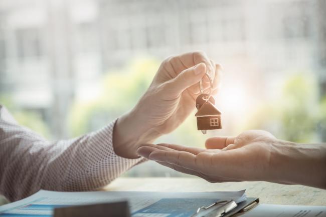 someone handing keys over to another person's hand