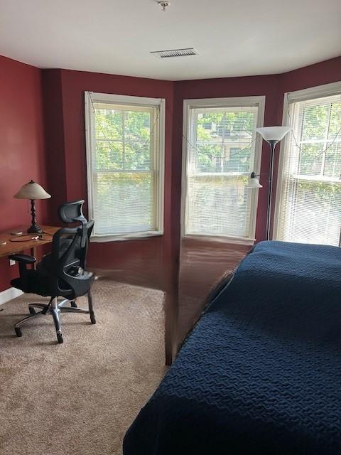 Secondary bedroom with bay windows and carpet flooring