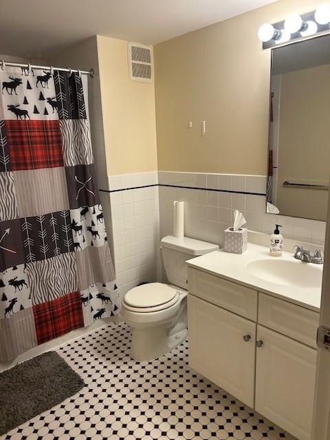 Secondary bathroom with tile flooring, toilet, tub/shower, and vanity