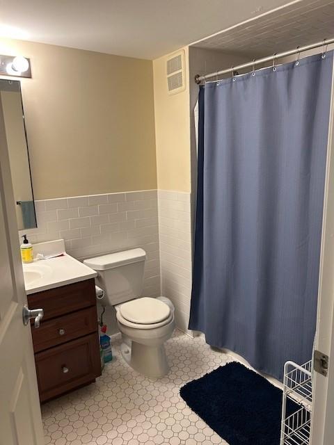 Primary bathroom with tile flooring, toilet, tub/shower, and vanity