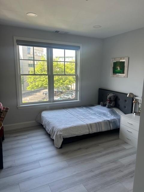 secondary bedroom with hard flooring and large windows