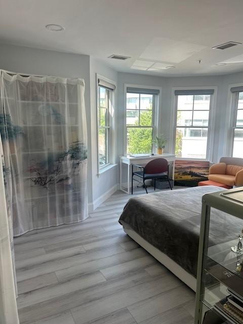 Primary bedroom with bay windows and hard flooring