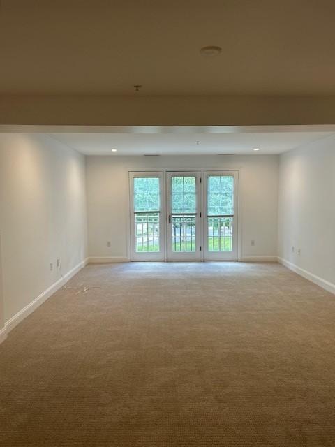 Open concept living/dining room facing the back large window, carpeted flooring