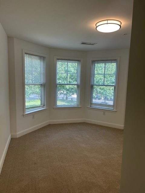 Secondary bedroom with large bay windows and carpeted flooring