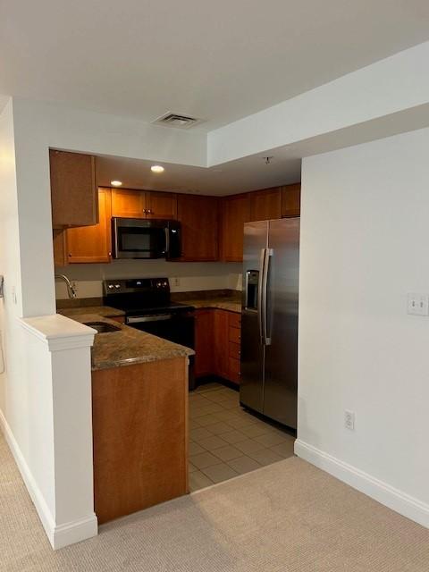 Kitchen with oak wood cabinetry and stainless steel appliances