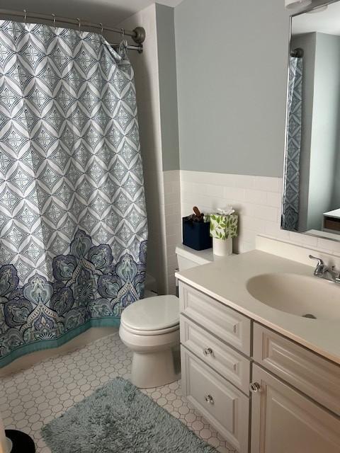 Primary bathroom with tiling, vanity, tub/shower