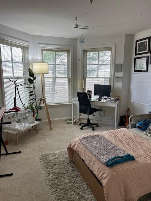 Second bedroom with carpet flooring and large bay windows
